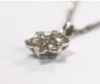 A modern 18k white metal and seven stone diamond cluster set flower head pendant, overall 15mm, on a 9ct white gold chain, 45cm, gross weight 3.2 grams.